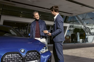 BMW Partl Neumarkt Inzahlungnahme zwei Personen vor BMW 4er